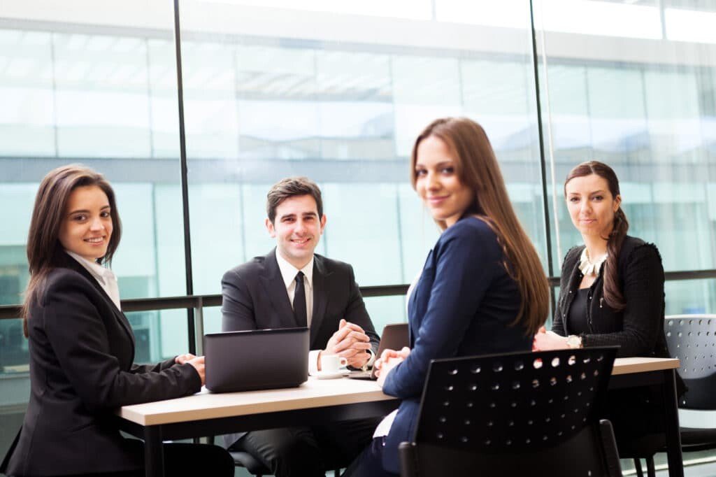 Group of business people smiling at the office, focus on man