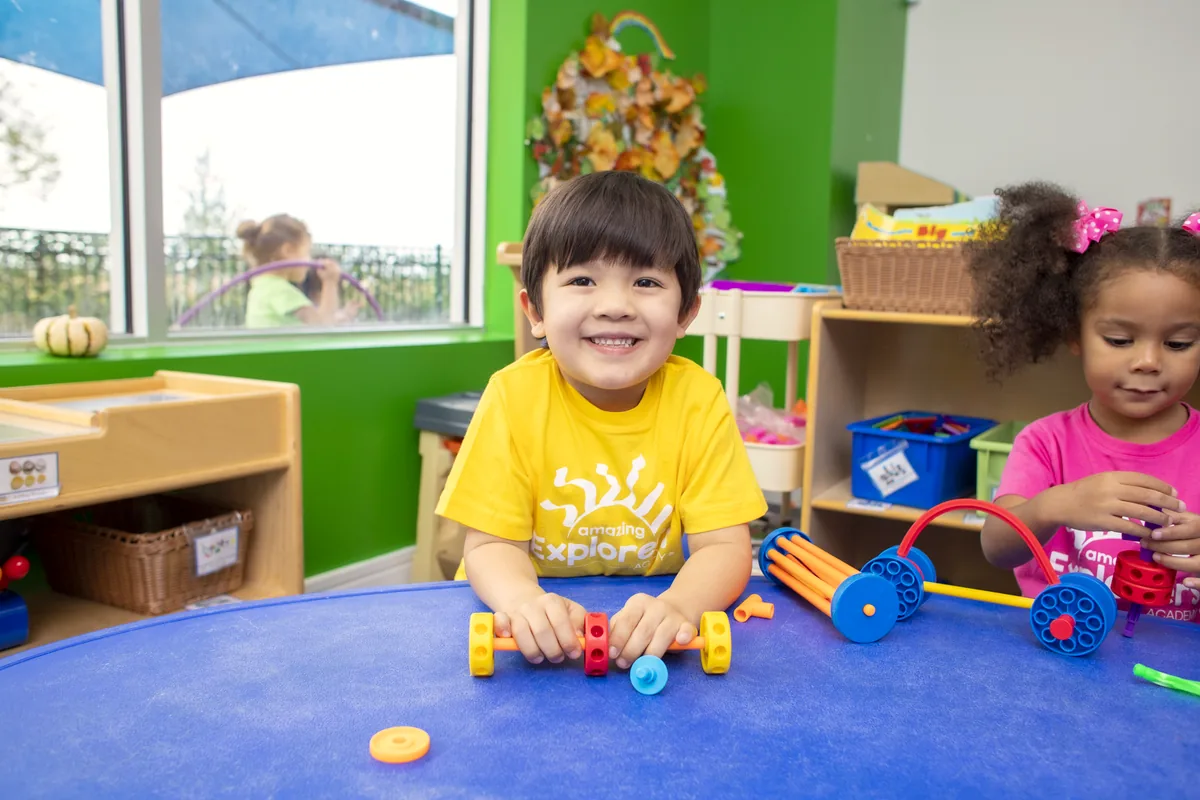 Young children playing with building blocks in a bright classroom