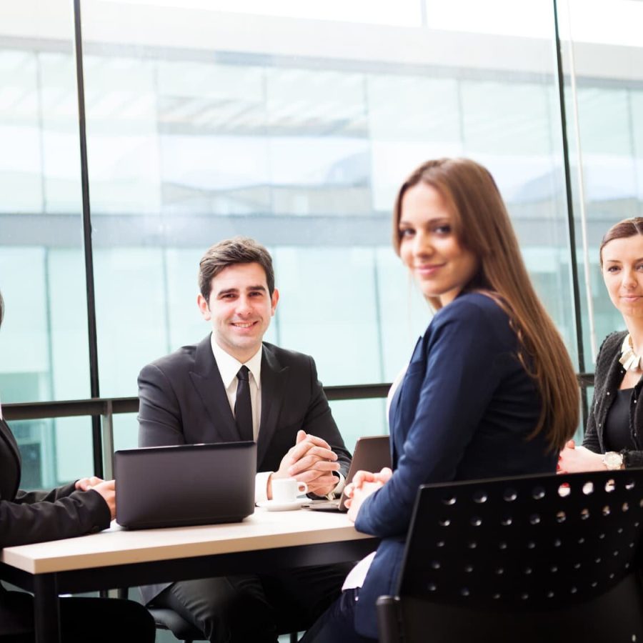 Group of business people smiling at the office, focus on man